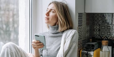 Woman looks at smartphone while listening to music
