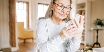 woman smiling and looking at her smartphone