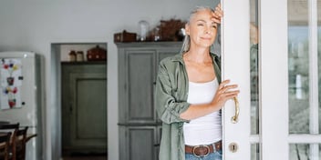 Woman looks out the door of the home she purchased after divorce
