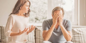 wife talks to husband who is covering his eyes and not listening