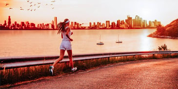 Woman runs along the waterfront at sunset