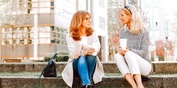 female colleagues taking a coffee break outside their office building