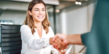 female employee shaking her boss's hand after a good meeting