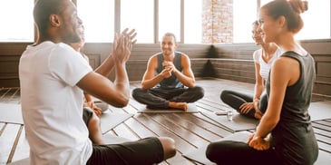 group of friends sitting in a yoga and meditation class