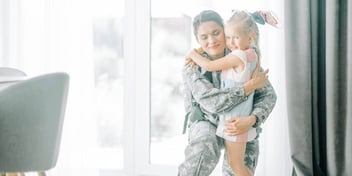 military mom hugging her daughter